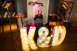 DJ performing during a wedding with K & D letters In front of him